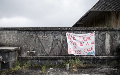 vandalized wall with hanging banner that reads 'we found love in a hopeless place'