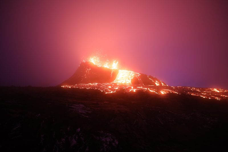 silhouette of erupting volcano during night time