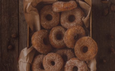 a basket of cinnamon sugar doughnuts on a wooden table