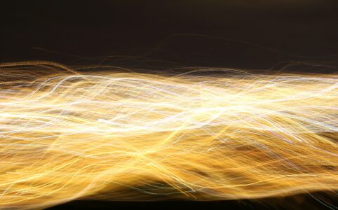 strands of yellow bright light swirled together across a black background