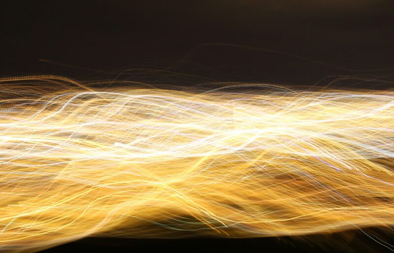 strands of yellow bright light swirled together across a black background