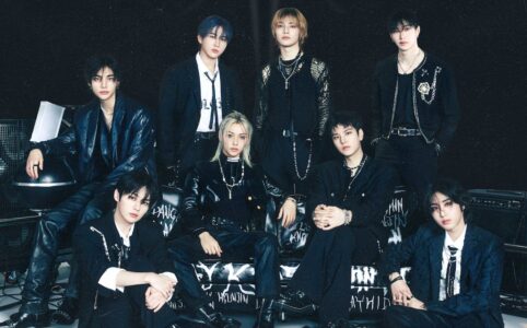 photoshoot of eight members of Stray Kids, all wearing black